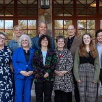 Suzanne Zack poses with a group outside of Alumni House